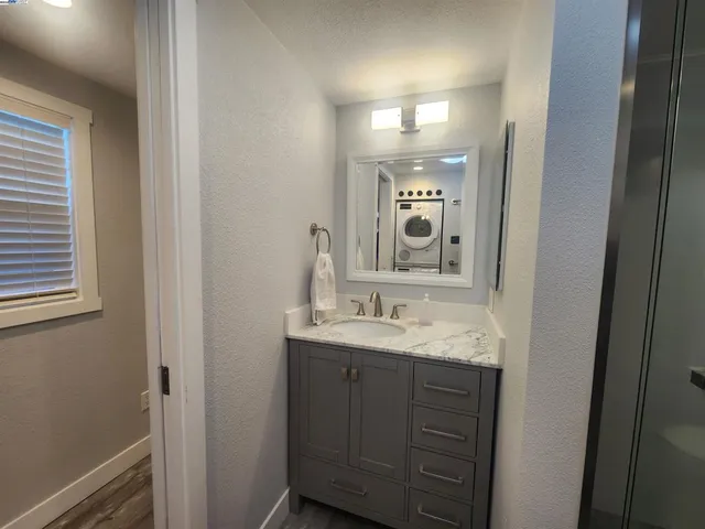 a bathroom with a granite countertop sink double vanity and a mirror