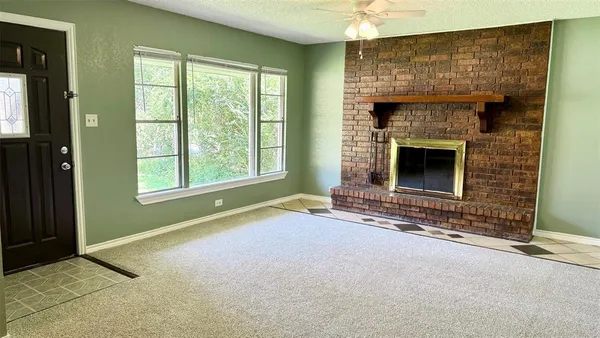 an empty room with windows and fireplace