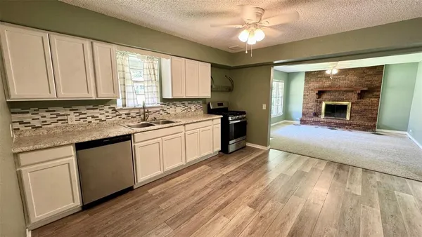 a kitchen with stainless steel appliances granite countertop a stove a sink and a microwave