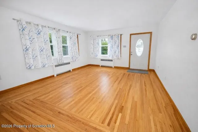 a view of a room with wooden floor and white walls