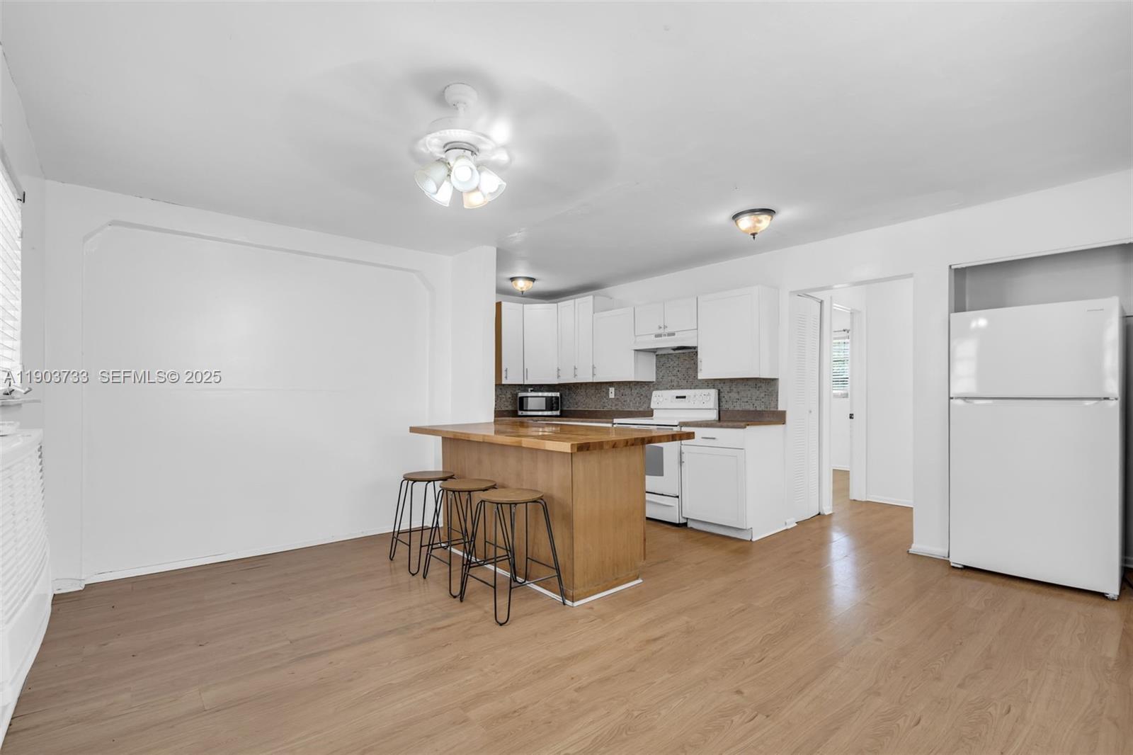 2809 Southwest 23rd Terrace, Unit 2807 Miami, FL 33145 - Photo 2 of 13 a kitchen with a refrigerator and white cabinets