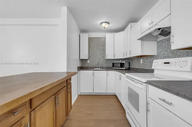 a kitchen with granite countertop a sink and cabinets