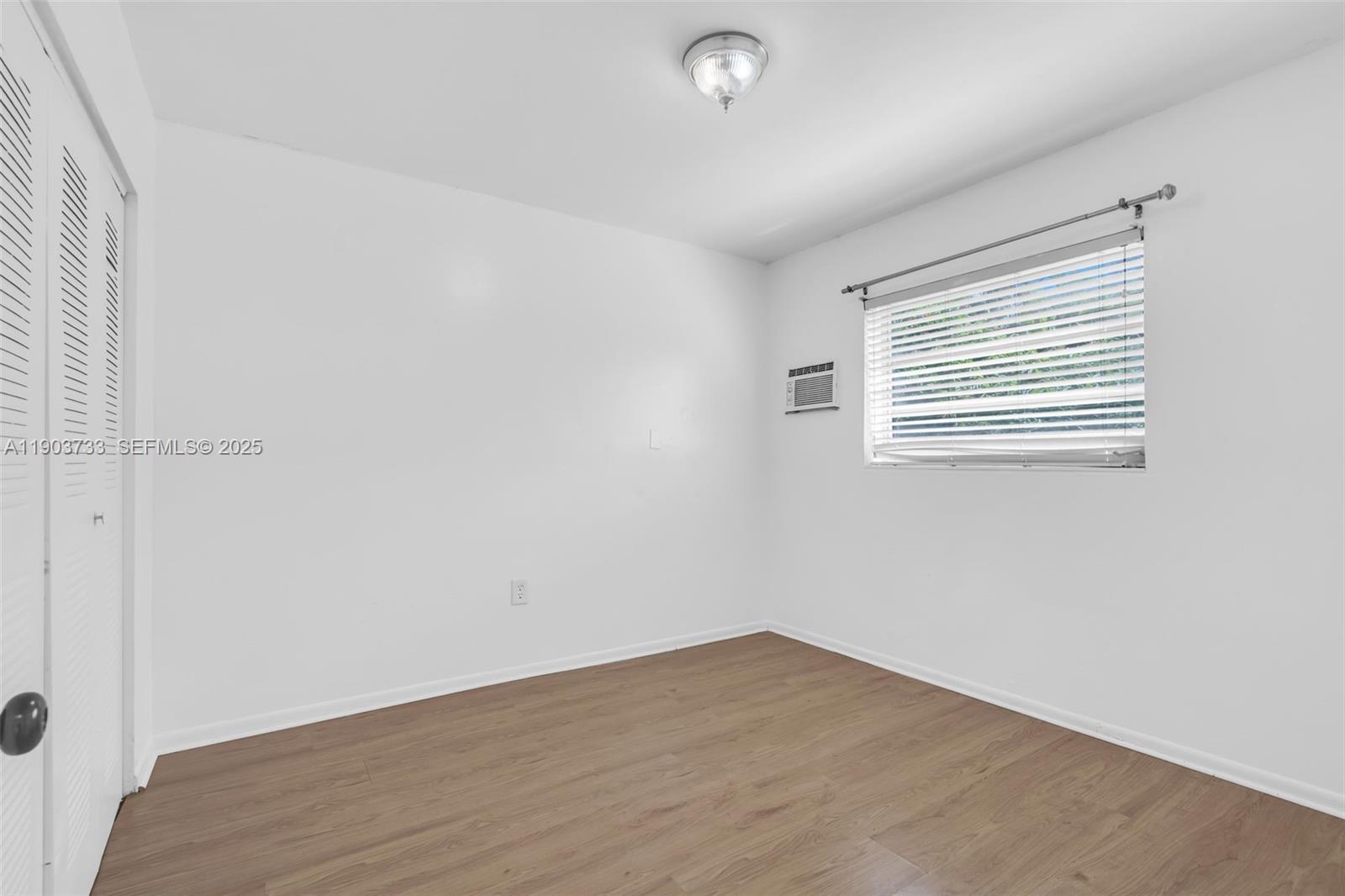 2809 Southwest 23rd Terrace, Unit 2807 Miami, FL 33145 - Photo 6 of 13 an empty room with wooden floor and windows