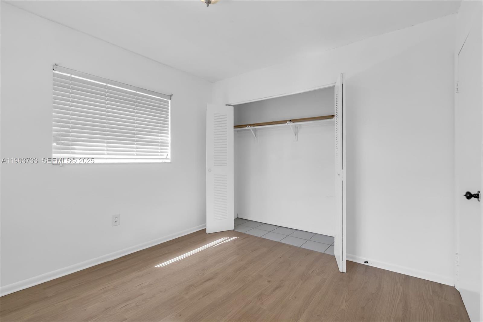 2809 Southwest 23rd Terrace, Unit 2807 Miami, FL 33145 - Photo 10 of 13 a view of an empty room with wooden floor and a window