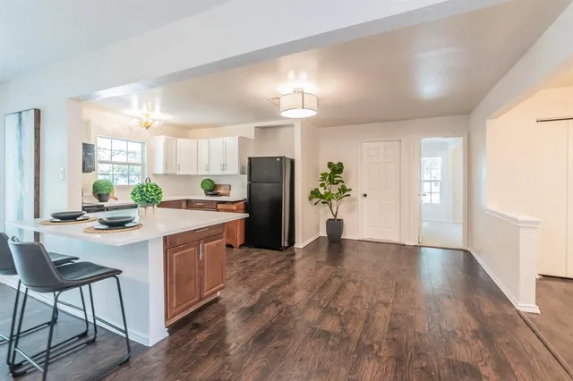 a kitchen with granite countertop a refrigerator and a stove top oven