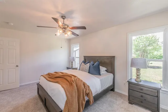 a bedroom with a bed chandelier and a window