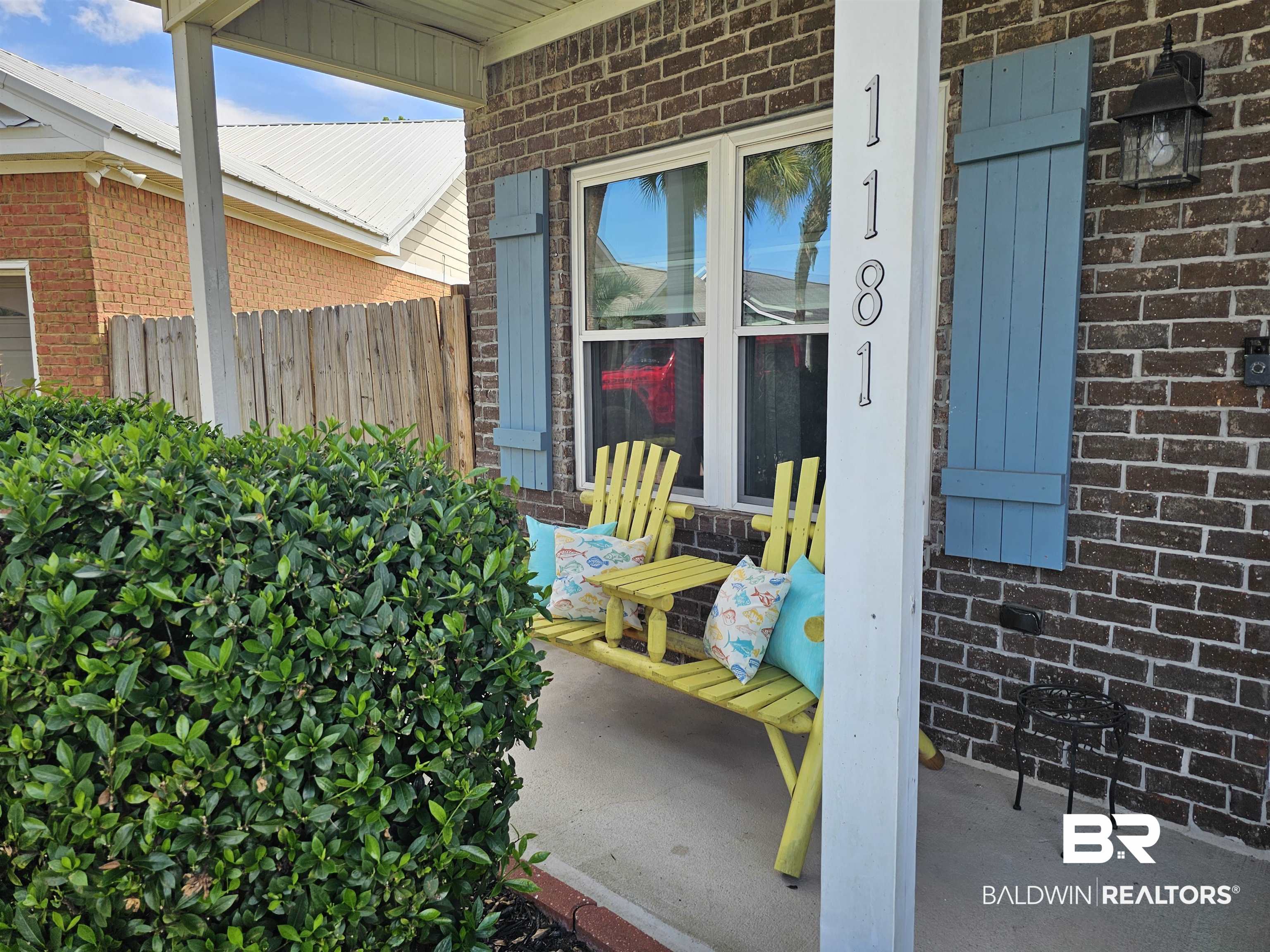 1181 Sloane Cove Foley, AL 36535 - Photo 3 of 10 Brick exterior featuring a covered porch with a concrete slab and manicured shrubbery