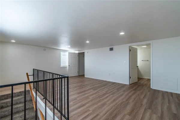a view of a hallway with wooden floor