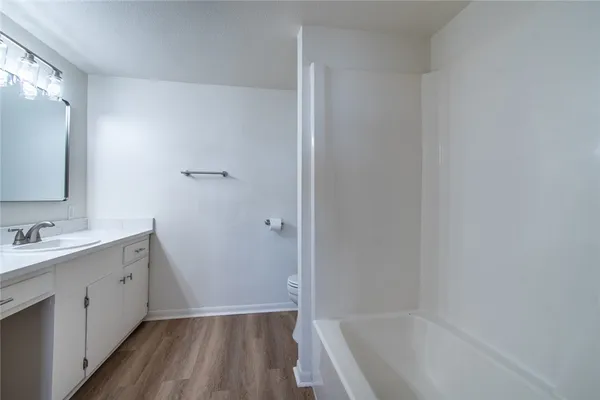 a bathroom with a tub sink and mirror