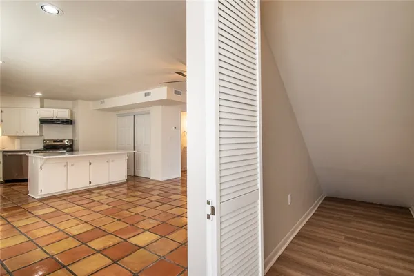 a view of a kitchen with wooden floor and a window