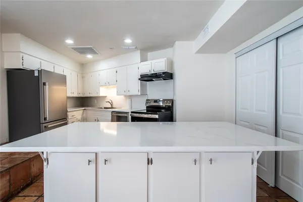 a kitchen with a refrigerator and a sink