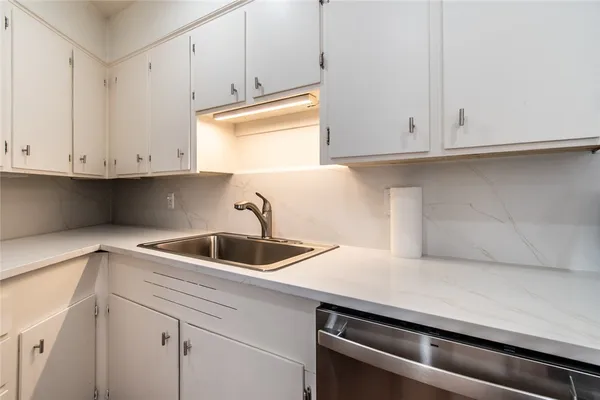 a kitchen with white cabinets and a sink