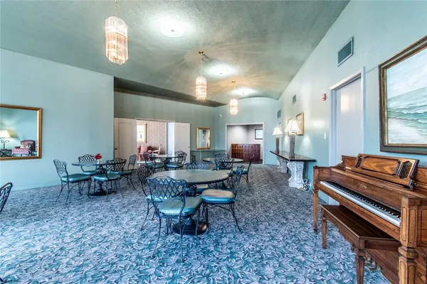 a living room with furniture piano and a table