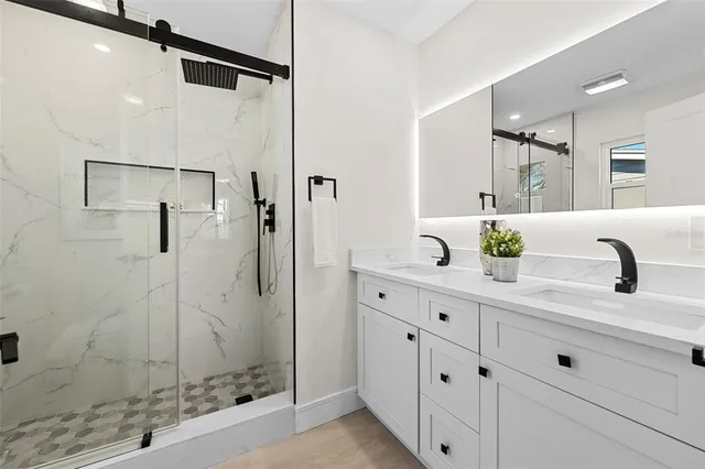 a bathroom with a shower sink and mirror
