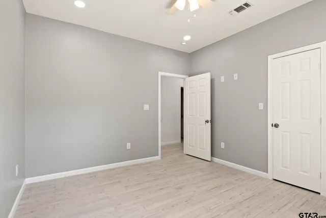 a view of an empty room with wooden floor