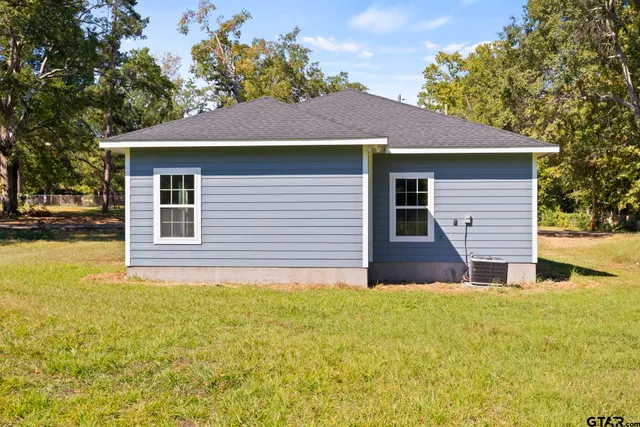 a front view of house with yard and trees around