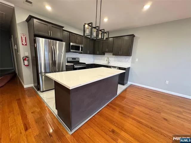 a kitchen with stainless steel appliances granite countertop a refrigerator and a sink