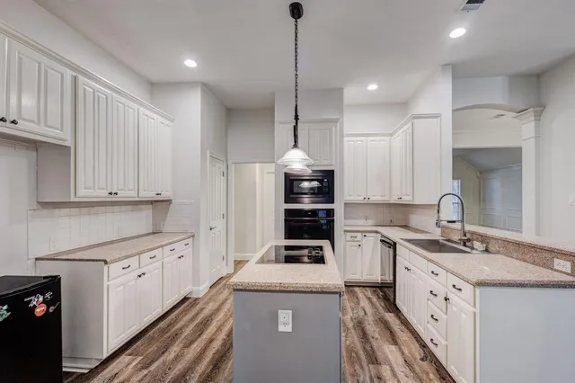 a kitchen with a sink a stove a refrigerator and cabinets