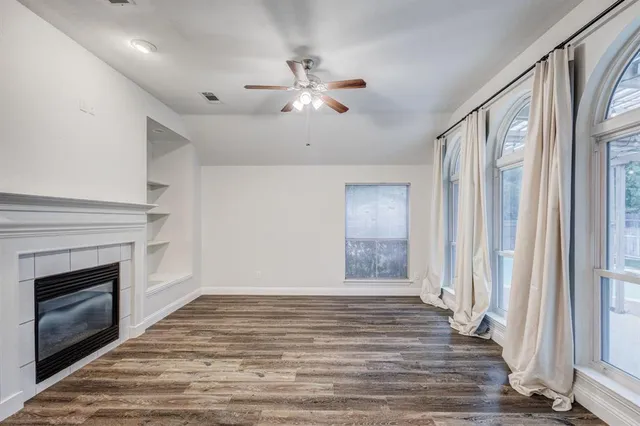 a view of an empty room with a fireplace and a window