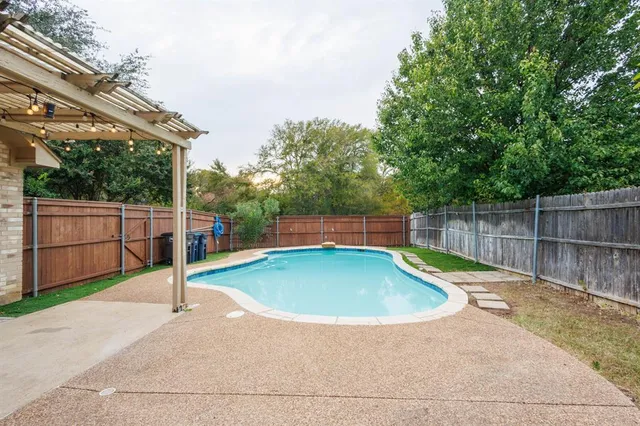 a view of a backyard with wooden fence