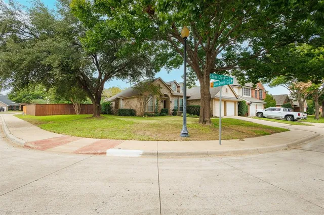 a view of a house with a big yard and large trees