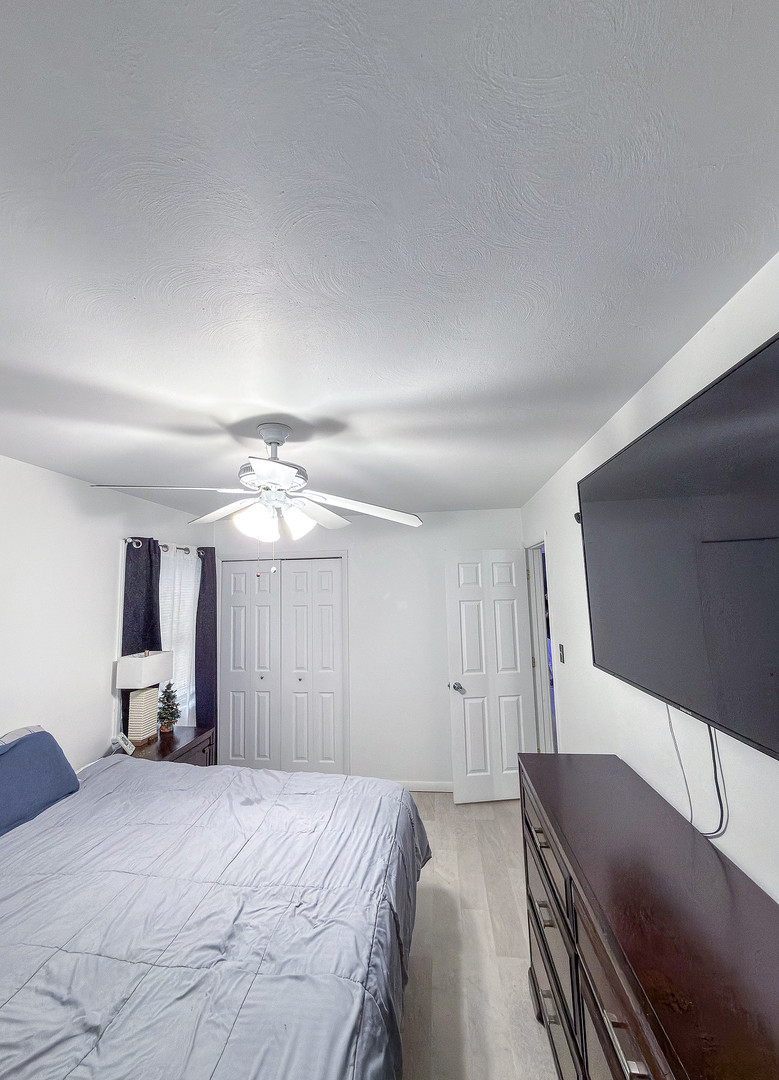 1709 West William Street Champaign, IL 61821 - Photo 12 of 20 a spacious bedroom with a bed and a chandelier