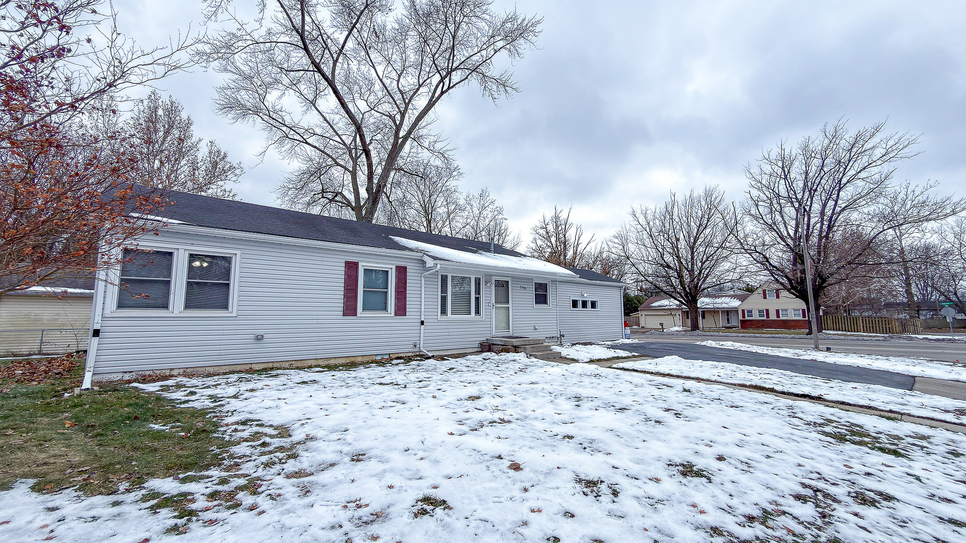 1709 West William Street Champaign, IL 61821 - Photo 4 of 20 a front view of a house with a yard covered in snow
