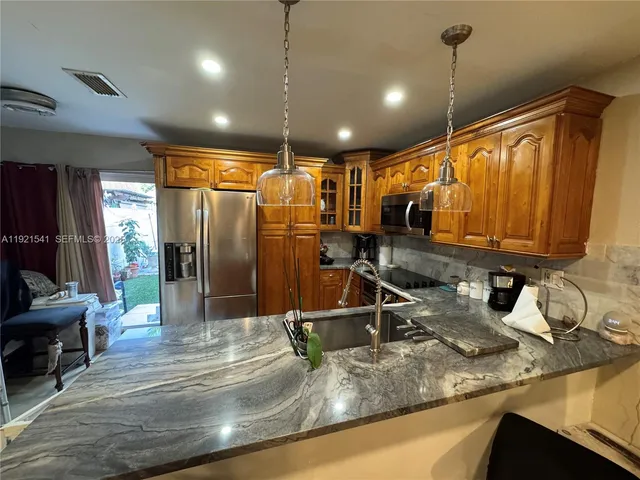 a kitchen with sink refrigerator and cabinets