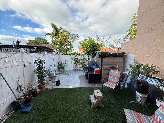 a view of a patio with table and chairs potted plants & fire pit