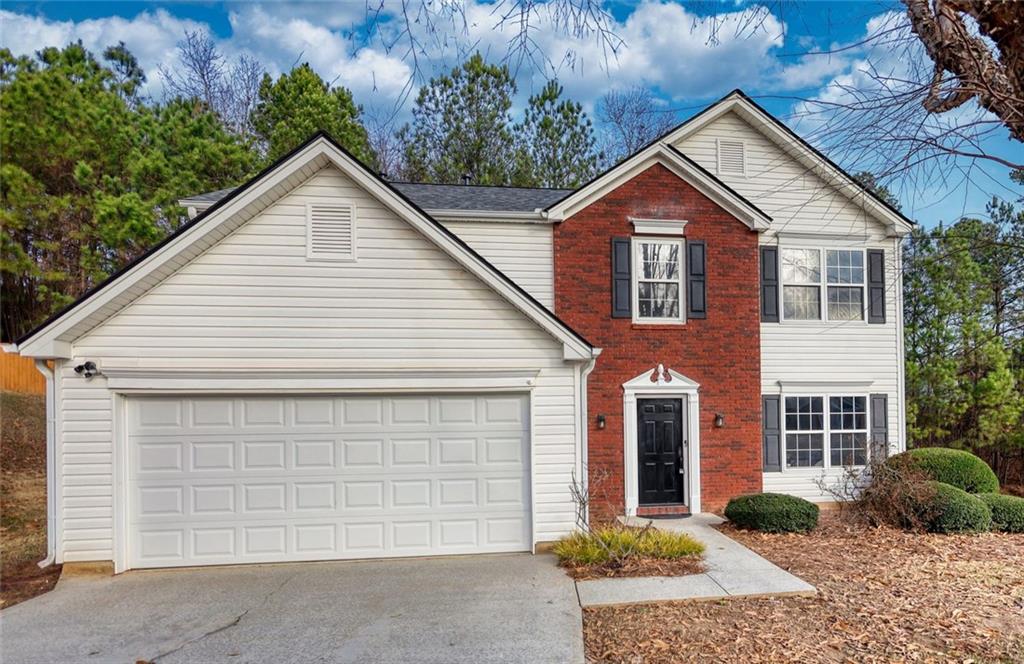 1328 Blazing Star Road Southeast Lawrenceville, GA 30045 - Photo 1 of 1 a front view of a house with a yard and garage