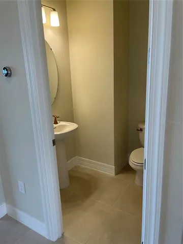 a bathroom with a granite countertop toilet and a sink