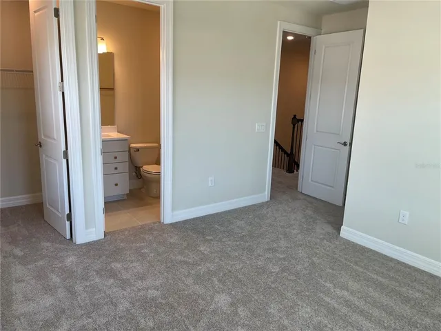 an empty room and a bathroom with a sink