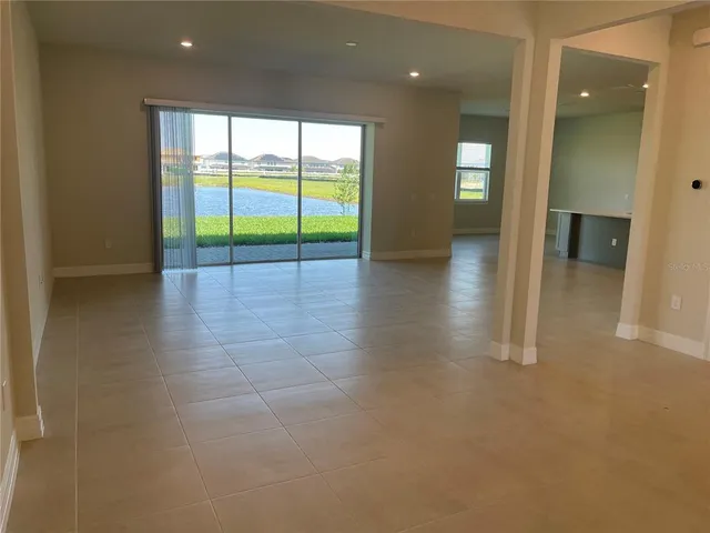 an empty room with floor to ceiling window and an outdoor view