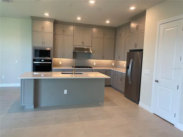 a kitchen with kitchen island white cabinets and refrigerator