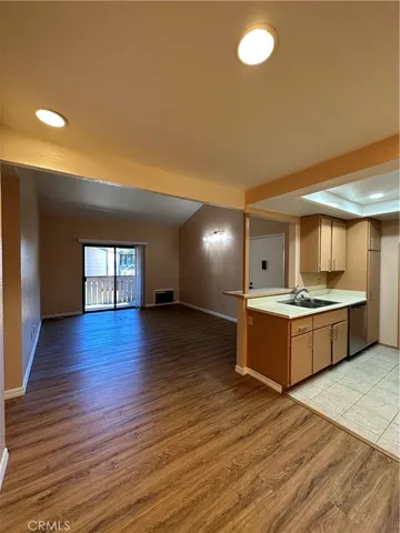 a large kitchen with wooden floors and stainless steel appliances