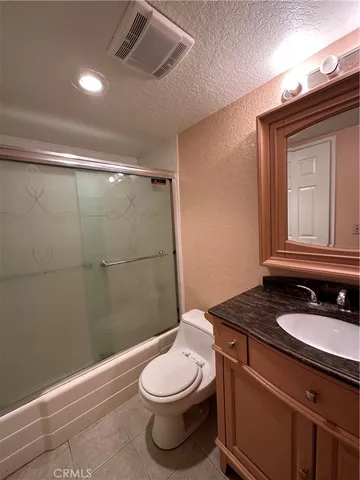 a bathroom with a granite countertop sink toilet a mirror and shower