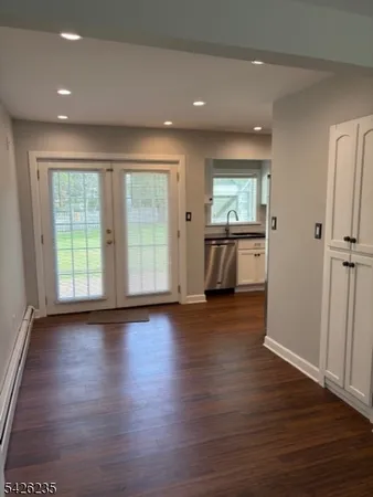 an empty room with wooden floor and window