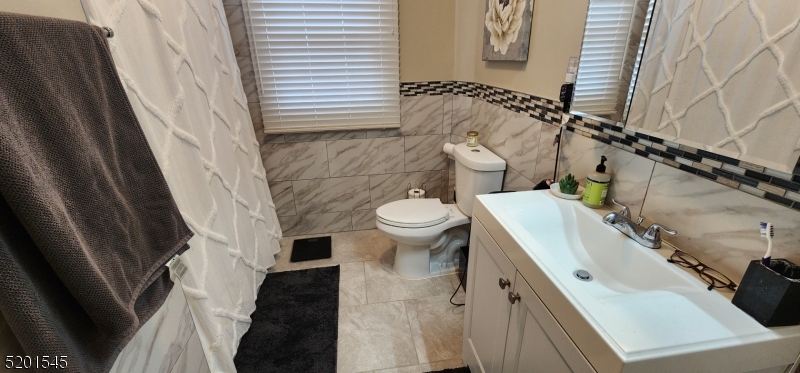 46 Cumberland Avenue, Unit 2 Verona, NJ 07044 - Photo 12 of 25 a bathroom with a sink a toilet and a mirror