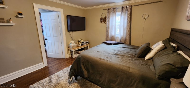 46 Cumberland Avenue, Unit 2 Verona, NJ 07044 - Photo 8 of 25 a bedroom with a bed and a flat tv screen on a dresser