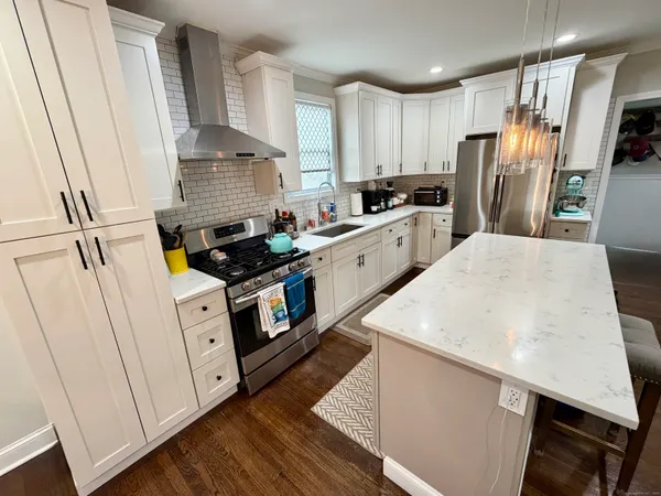 a kitchen with a sink a refrigerator a stove and cabinets