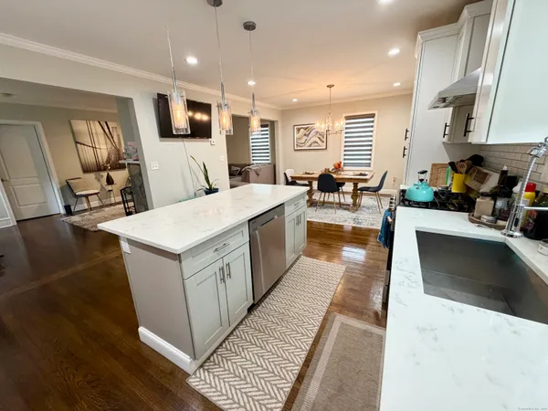 a large white kitchen with lots of counter top space a sink and appliances