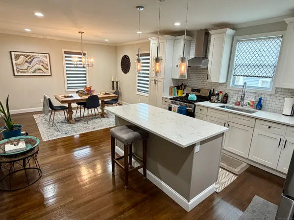 a kitchen with a stove a refrigerator and wooden floor