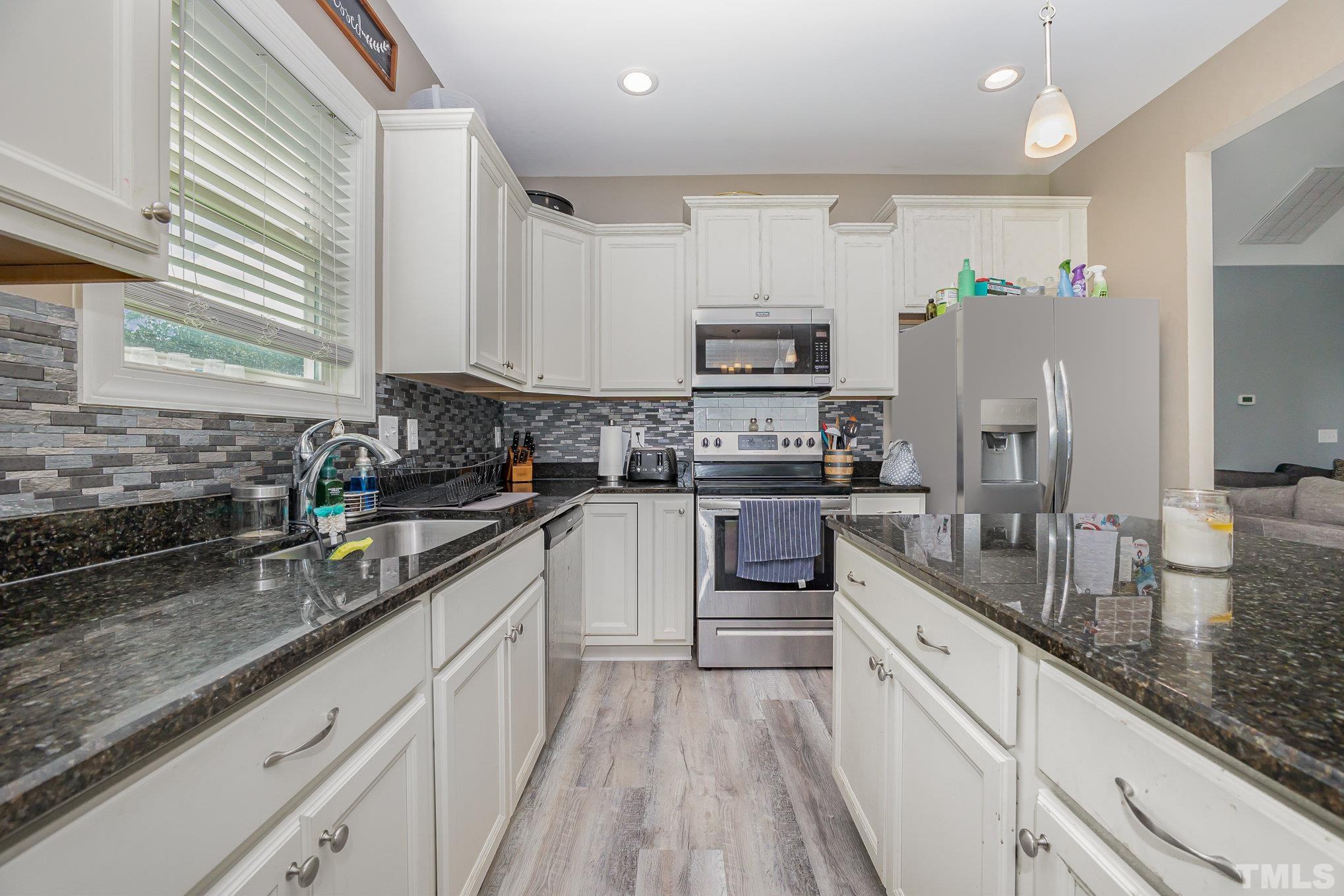 16 Chaparral Trail Garner, NC 27529 - Photo 12 of 29 a kitchen with kitchen island granite countertop lots of counter top space a sink and appliances