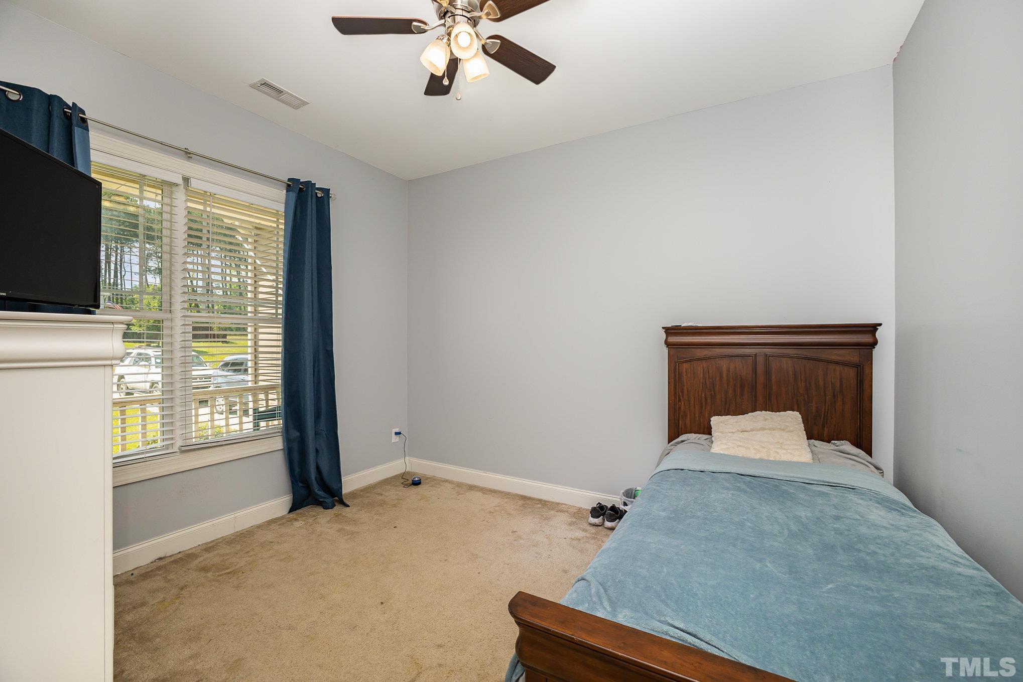 16 Chaparral Trail Garner, NC 27529 - Photo 16 of 29 a bedroom with a bed and a chandelier