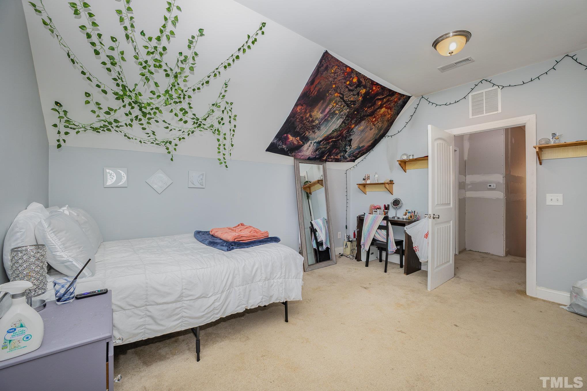 16 Chaparral Trail Garner, NC 27529 - Photo 20 of 29 a bedroom with bed and a chandelier