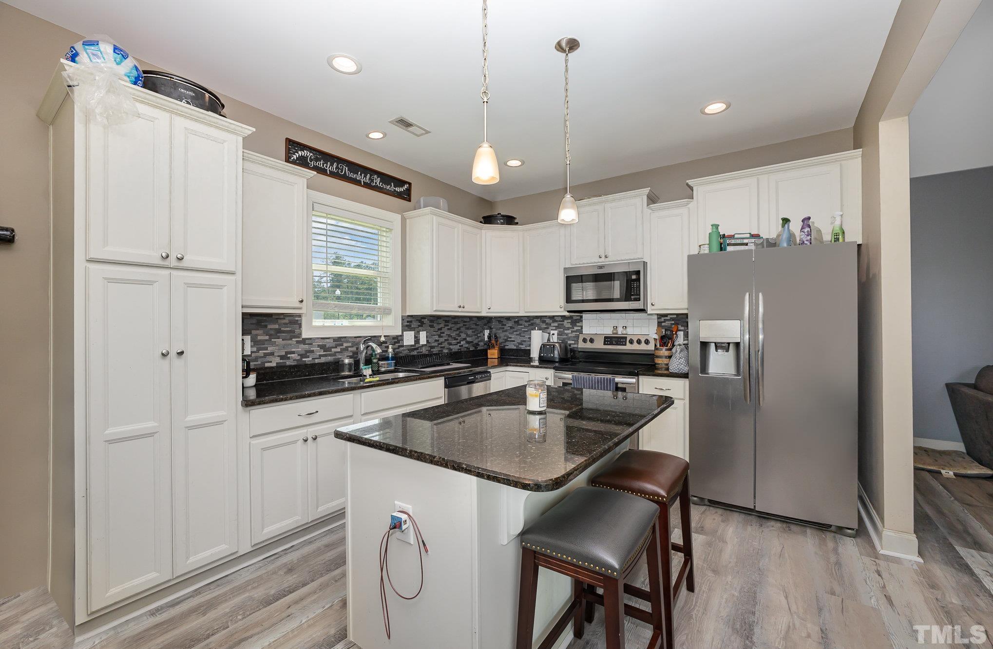 16 Chaparral Trail Garner, NC 27529 - Photo 10 of 29 a kitchen with a refrigerator a sink and cabinets