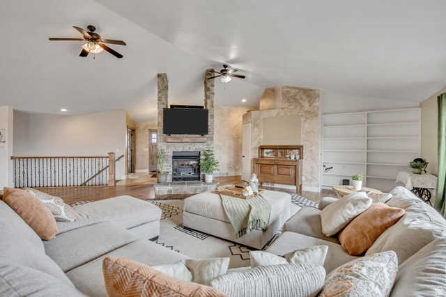 3054 West Ridgeline Road Stockton, UT 84071 - Photo 33 of 88 Living area with wood finished floors, lofted ceiling, a stone fireplace, ceiling fan, and built in shelves