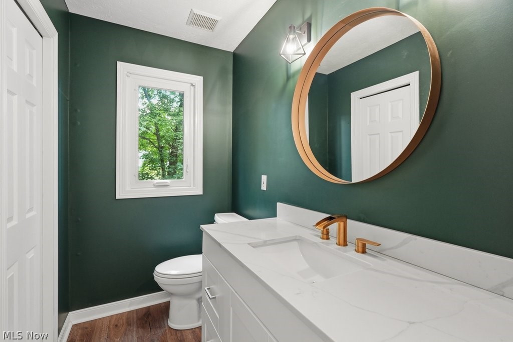 2323 Call Road Stow, OH 44224 - Photo 23 of 42 Guest bathroom- featuring a white vanity with a rectangular integrated sink, gold-finish faucet, and a large circular mirror