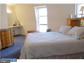 11849B Academy Road, Unit A49 Philadelphia, PA 19154 - Photo 5 of 6 a bedroom with a bed and wooden floor