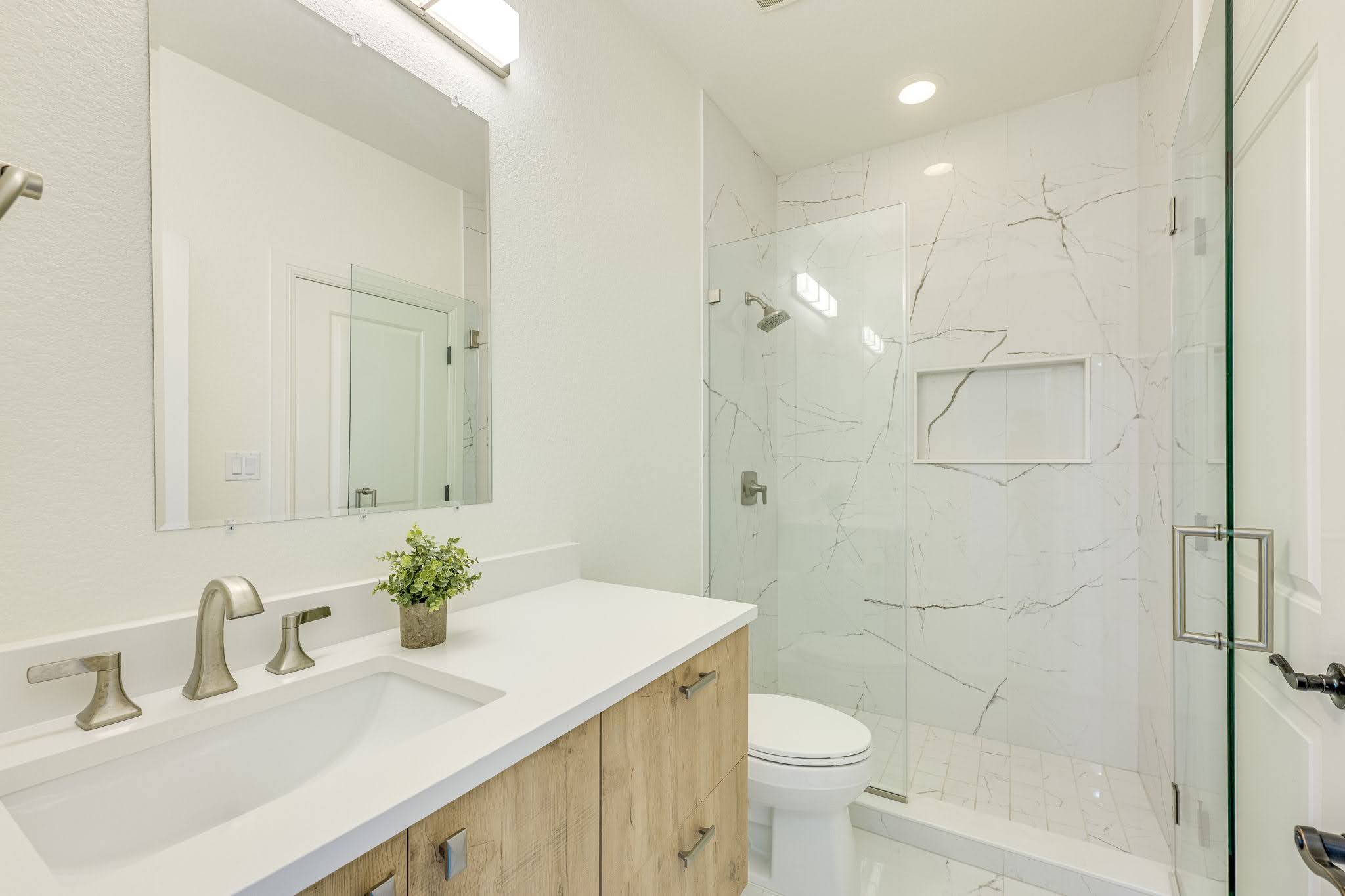 11612 Shoreview Overlook Austin, TX 78732 - Photo 32 of 40 Clean lines and stone counters highlight this modern washroom featuring a glass-enclosed walk-in shower.